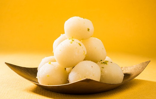 Bangladesh or india's favourite sweet rasgulla, dry rasgulla, bengal sweets, made of milk / khoya, sweet meets, curved in a steel plate, extreme closeup, front angle
